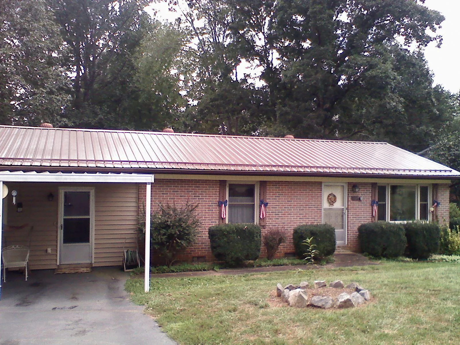 Bronze metal roof and carport on a brick ranch home — Roof Repair work by our crew in Laveen